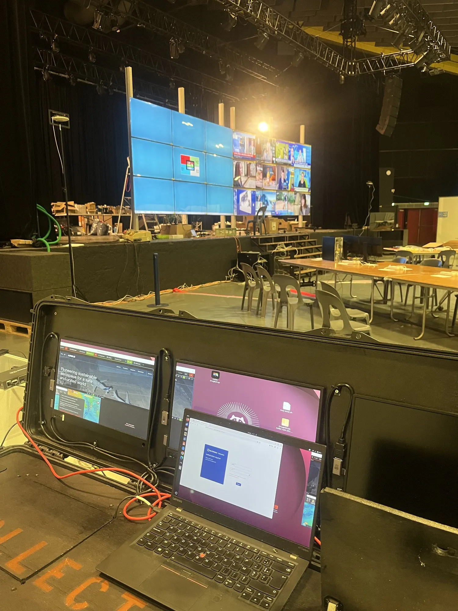 La maleta abierta al pie del escenario, los dos muros de vídeo de 9 pantallas encendidos detrás, en la sala de control de Lourdes 2026