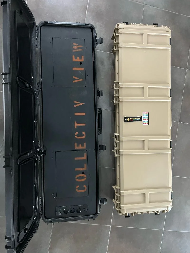 Zwei taktische Koffer auf dem Boden: links eine geöffnete schwarze Version mit CollectivView-Aufdruck und den Plätzen für die Bildschirme, rechts der geschlossene Prototyp v4 in Sandbeige